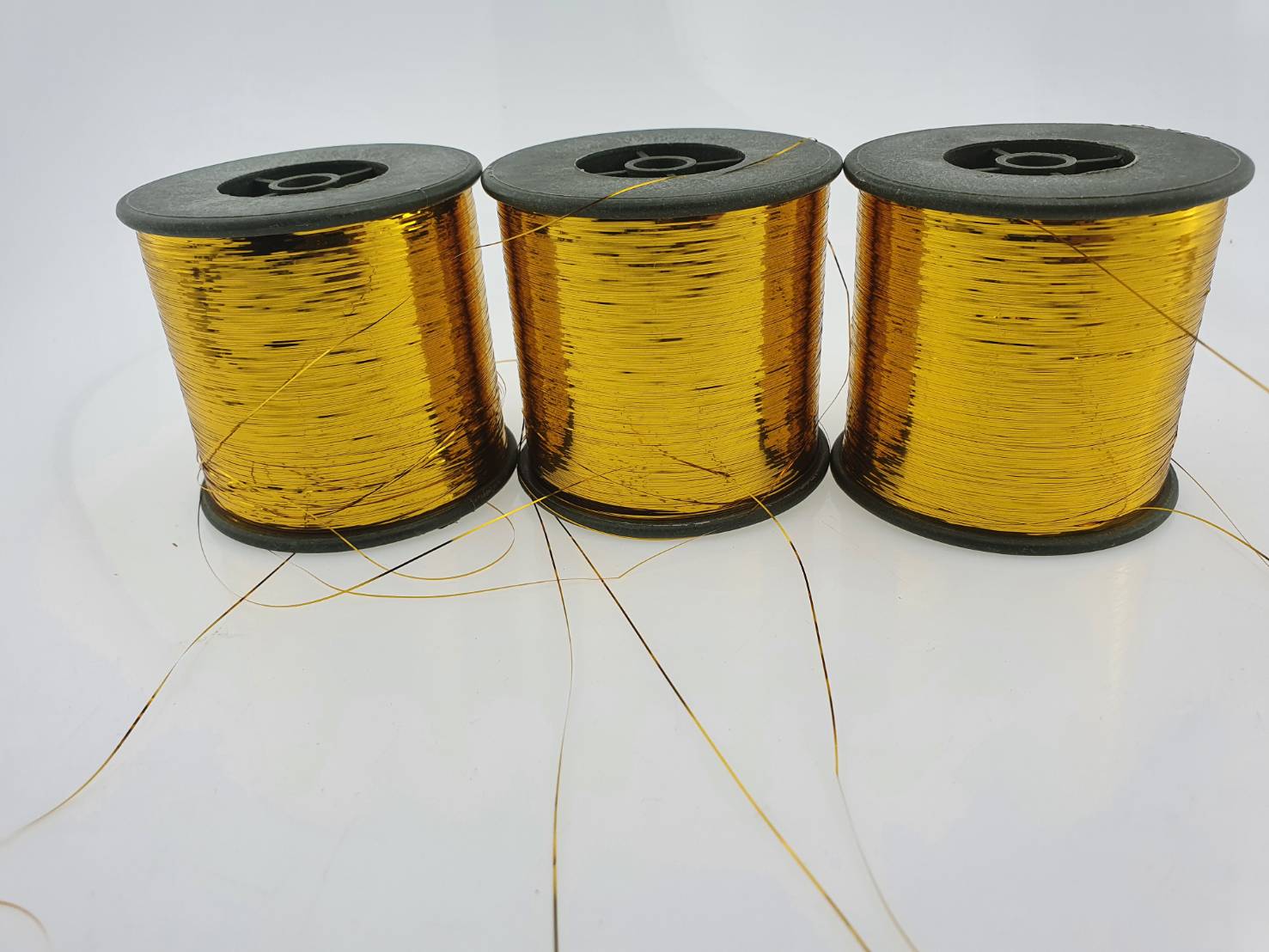 ดิ้นแบน (Metallic yarn) สีทอง สำหรับงานทอพรม งานปัก และงานทอดิ้นขนาด 125 กรัมต่อหลอดความกว้าง 0.36 มิลลิเมตร