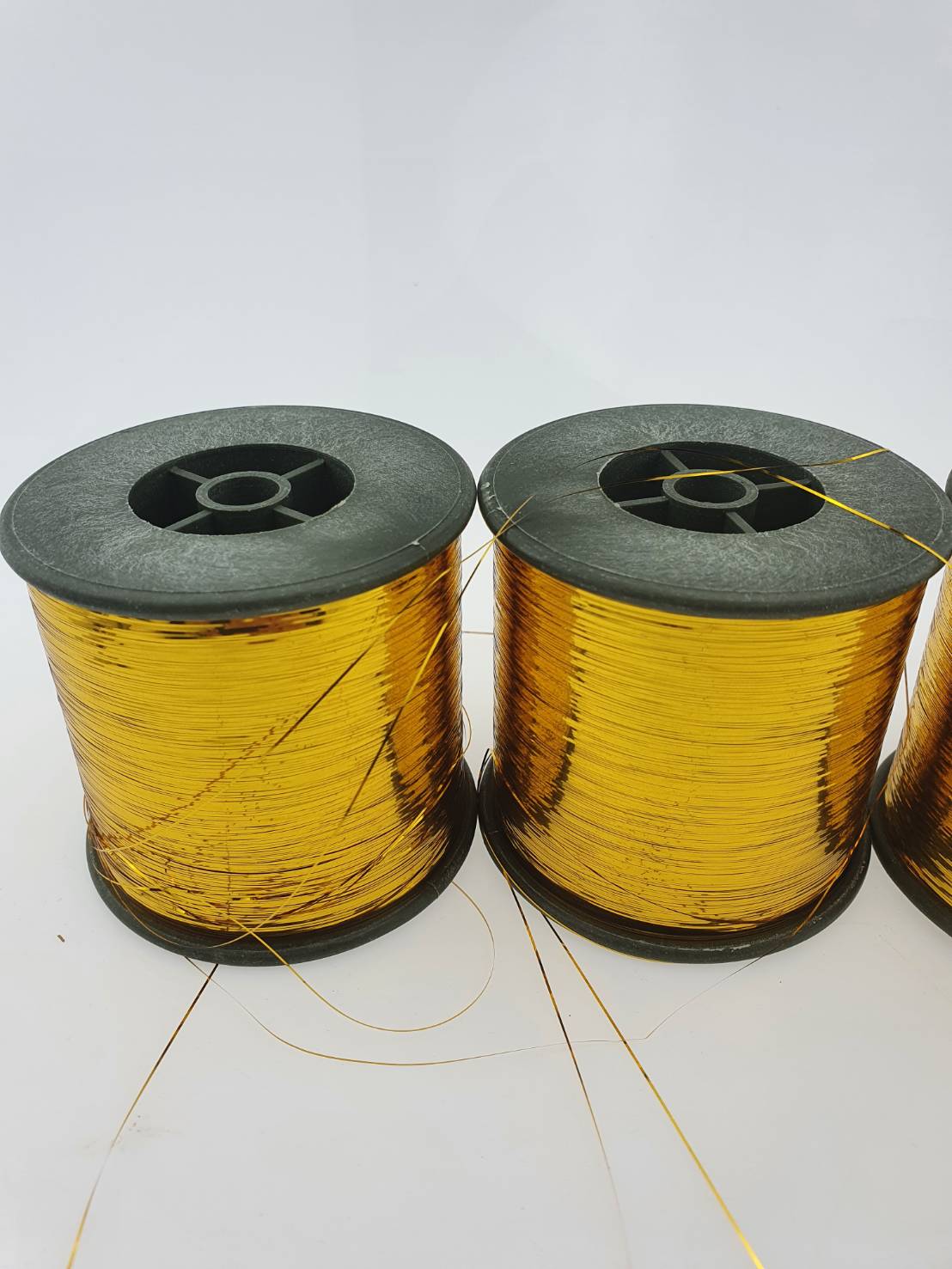 ดิ้นแบน (Metallic yarn) สีทอง สำหรับงานทอพรม งานปัก และงานทอดิ้นขนาด 125 กรัมต่อหลอดความกว้าง 0.36 มิลลิเมตร