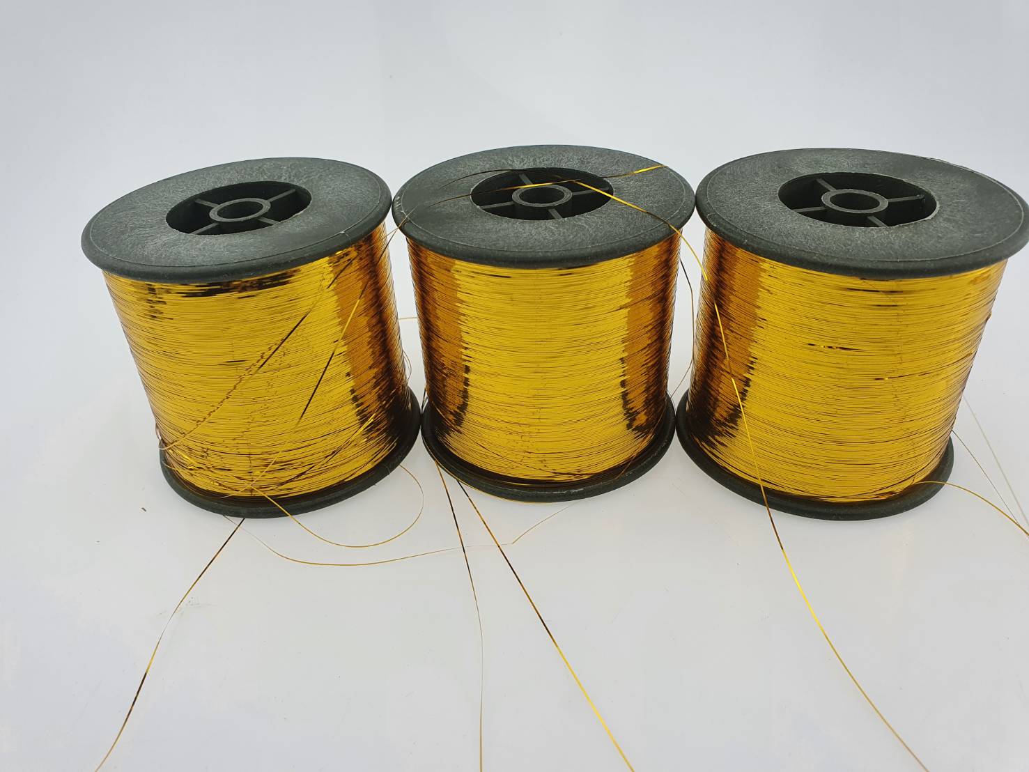 ดิ้นแบน (Metallic yarn) สีทอง สำหรับงานทอพรม งานปัก และงานทอดิ้นขนาด 125 กรัมต่อหลอดความกว้าง 0.36 มิลลิเมตร