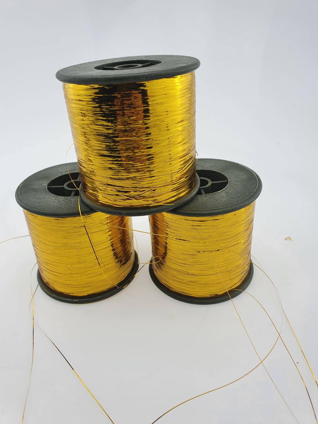 ดิ้นแบน (Metallic yarn) สีทอง สำหรับงานทอพรม งานปัก และงานทอดิ้นขนาด 125 กรัมต่อหลอดความกว้าง 0.36 มิลลิเมตร