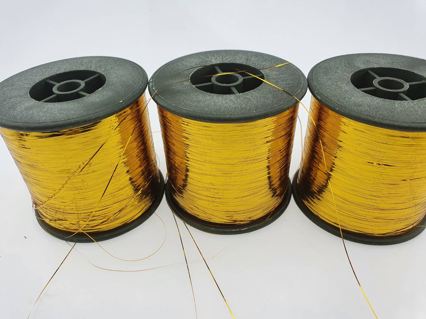 ดิ้นแบน (Metallic yarn) สีทอง สำหรับงานทอพรม งานปัก และงานทอดิ้นขนาด 125 กรัมต่อหลอดความกว้าง 0.36 มิลลิเมตร