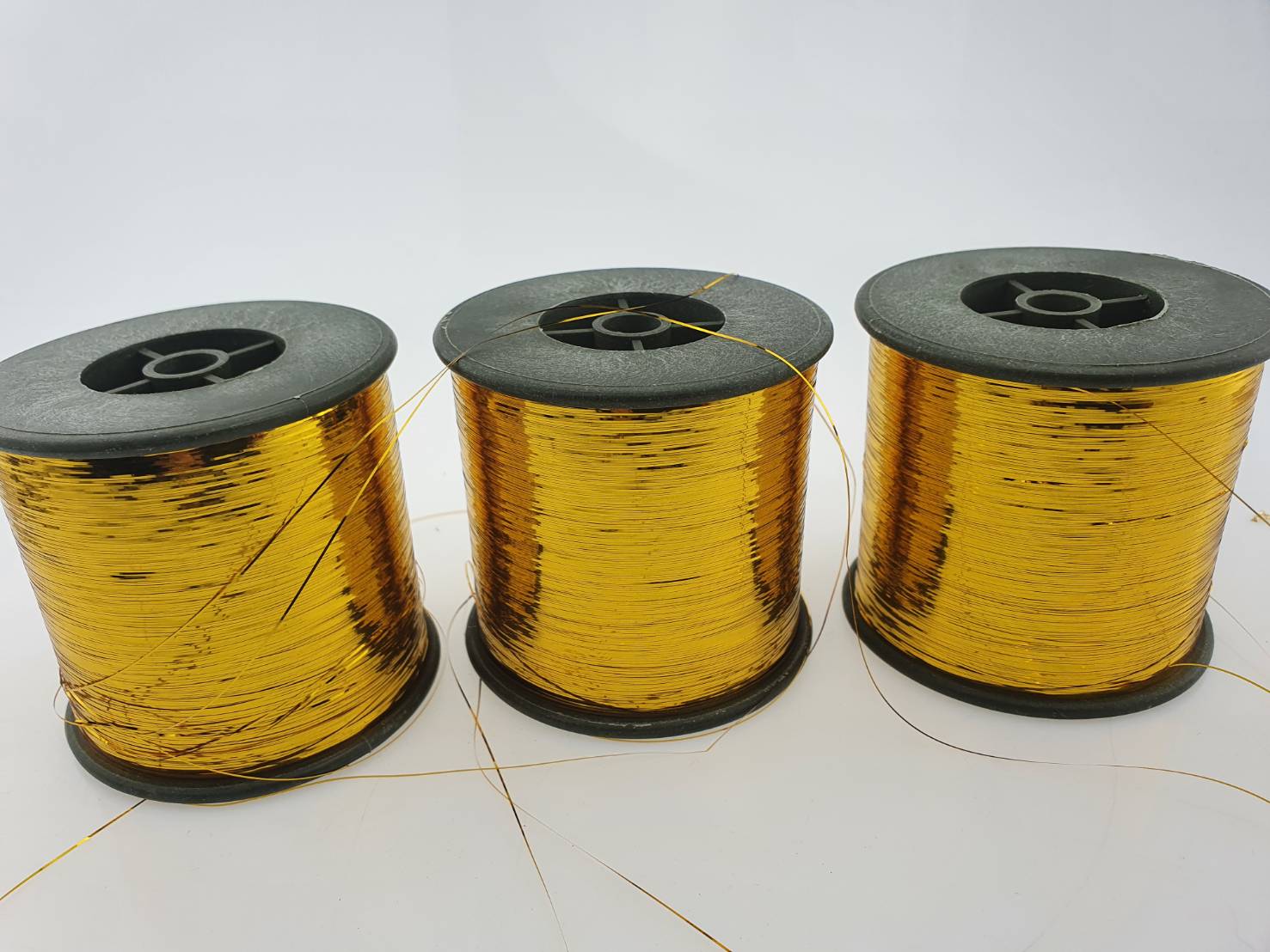 ดิ้นแบน (Metallic yarn) สีทอง สำหรับงานทอพรม งานปัก และงานทอดิ้นขนาด 125 กรัมต่อหลอดความกว้าง 0.36 มิลลิเมตร