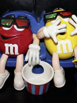 หนุ่ม M&M สีเหลืองและแดงกำลังนั่งชมภาพยนต์ 3 มิติ ด้วยแว่นตา (มือสอง มีตำหนิ)